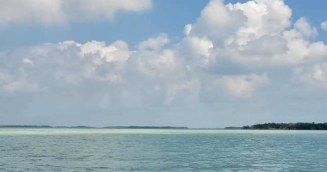Open ocean seascape with distant islands and dramatic clouds