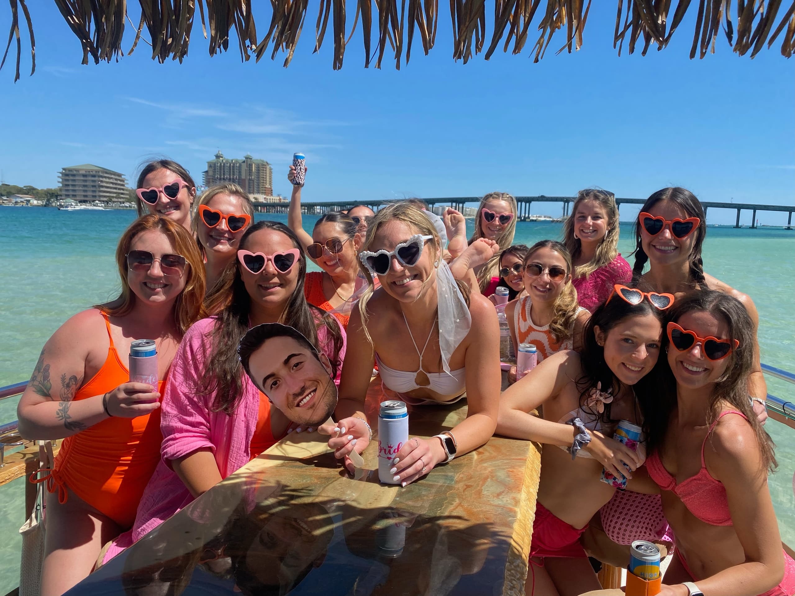 Large group posing on anchored party boat in clear coastal waters