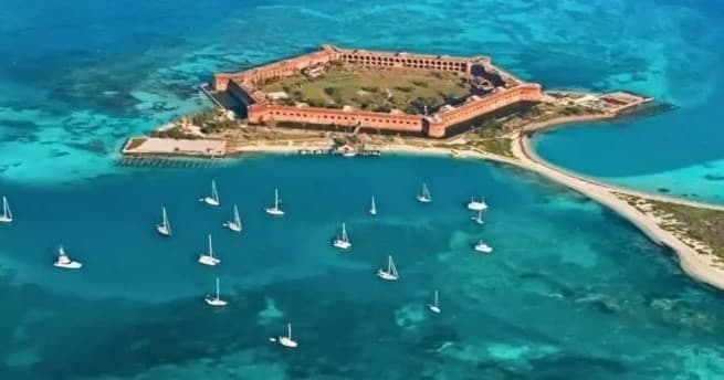 Aerial view of fortress island and sailboats in turquoise sea