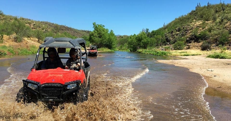 UTV splashing through river crossing on scenic desert trail