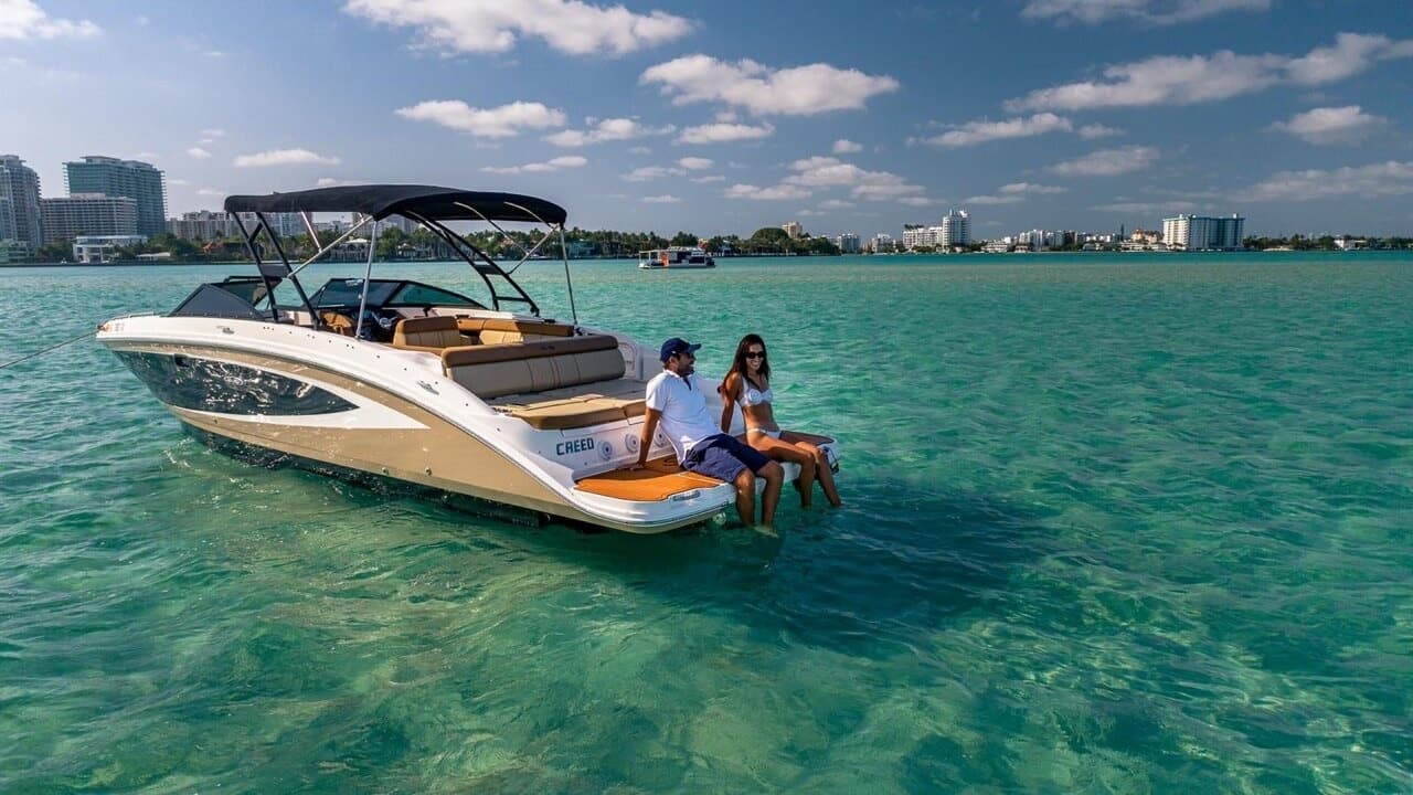 Luxury boat anchored in clear shallow water with guests onboard