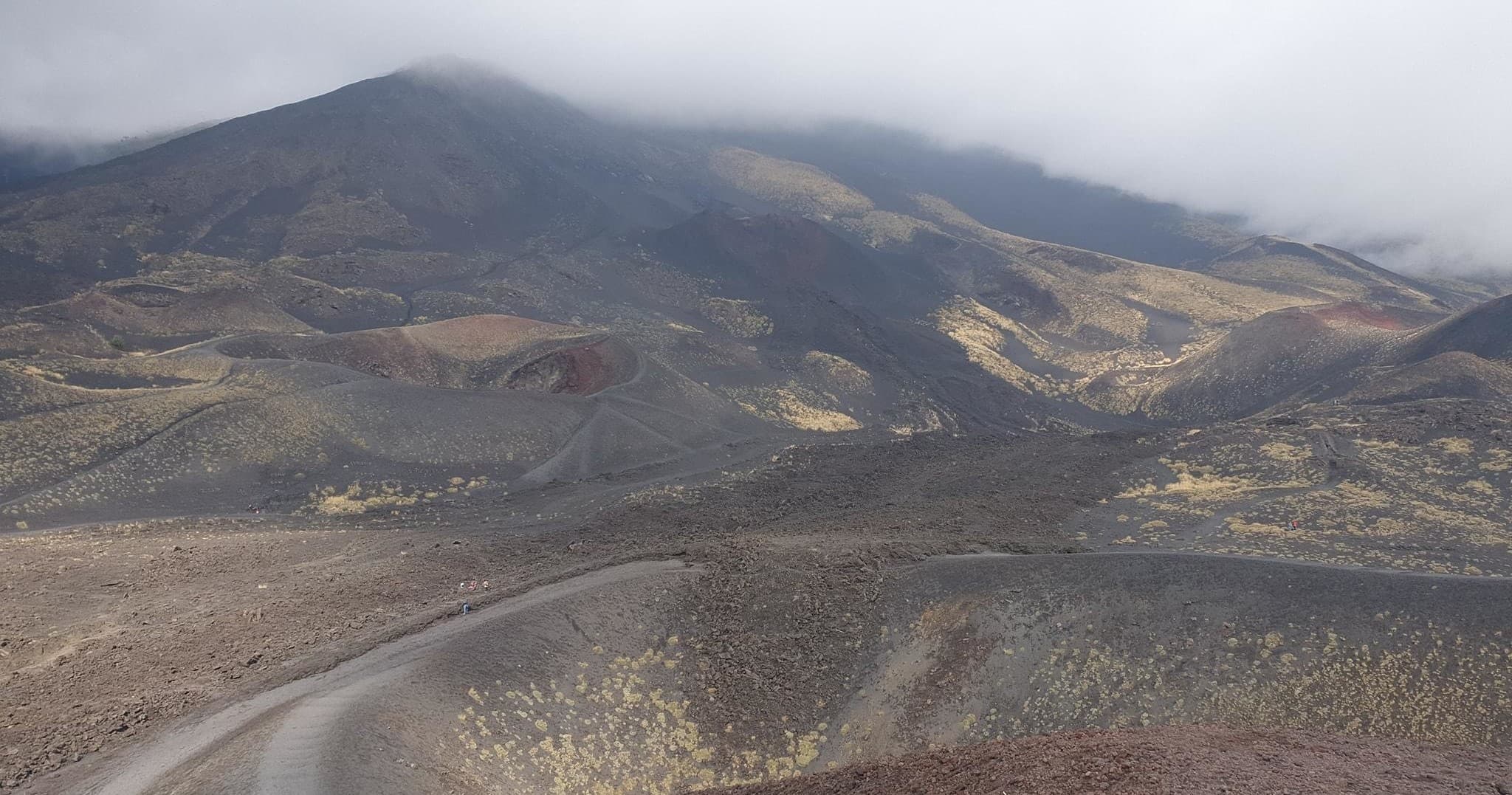 Foggy volcanic landscape with winding road across barren slopes