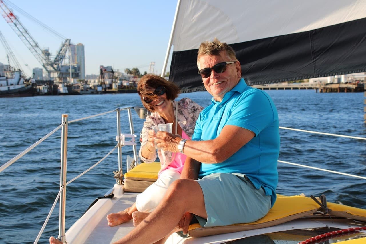 Smiling man enjoying sailboat bow on scenic harbor cruise
