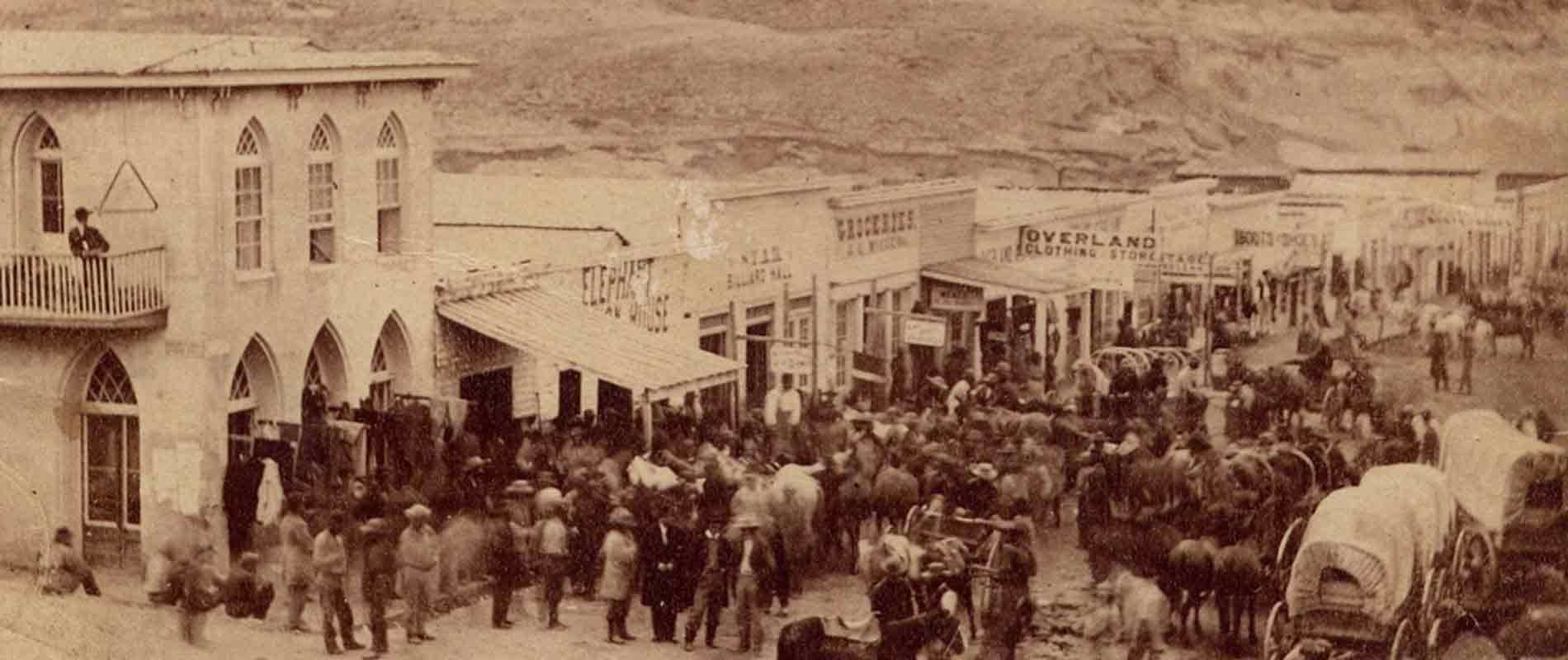 Crowded historic Virginia City street with wagons and spectators