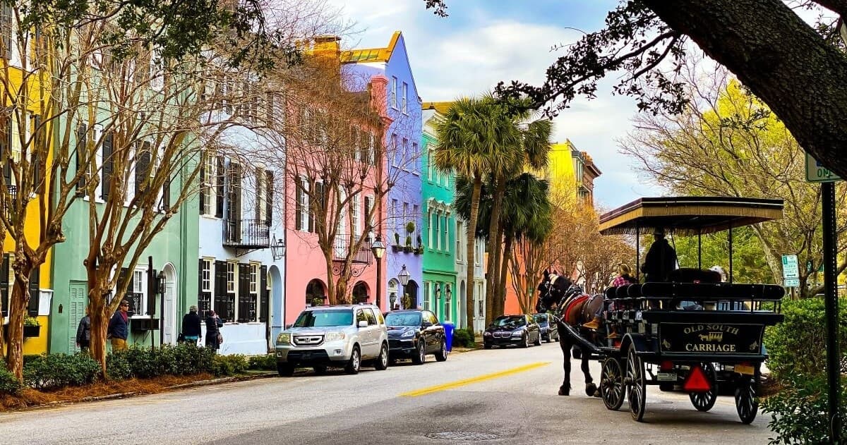 Horse carriage passing pastel Rainbow Row houses in Charleston