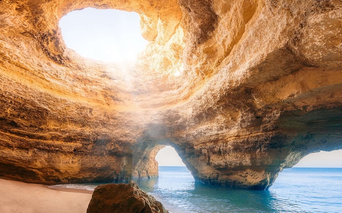 Sunlit sea cave beach (Benagil) accessed on coastal boat tour