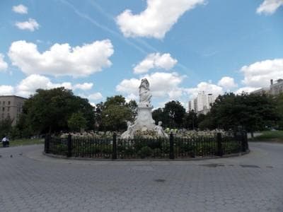 Historic park fountain in city square with open green plaza