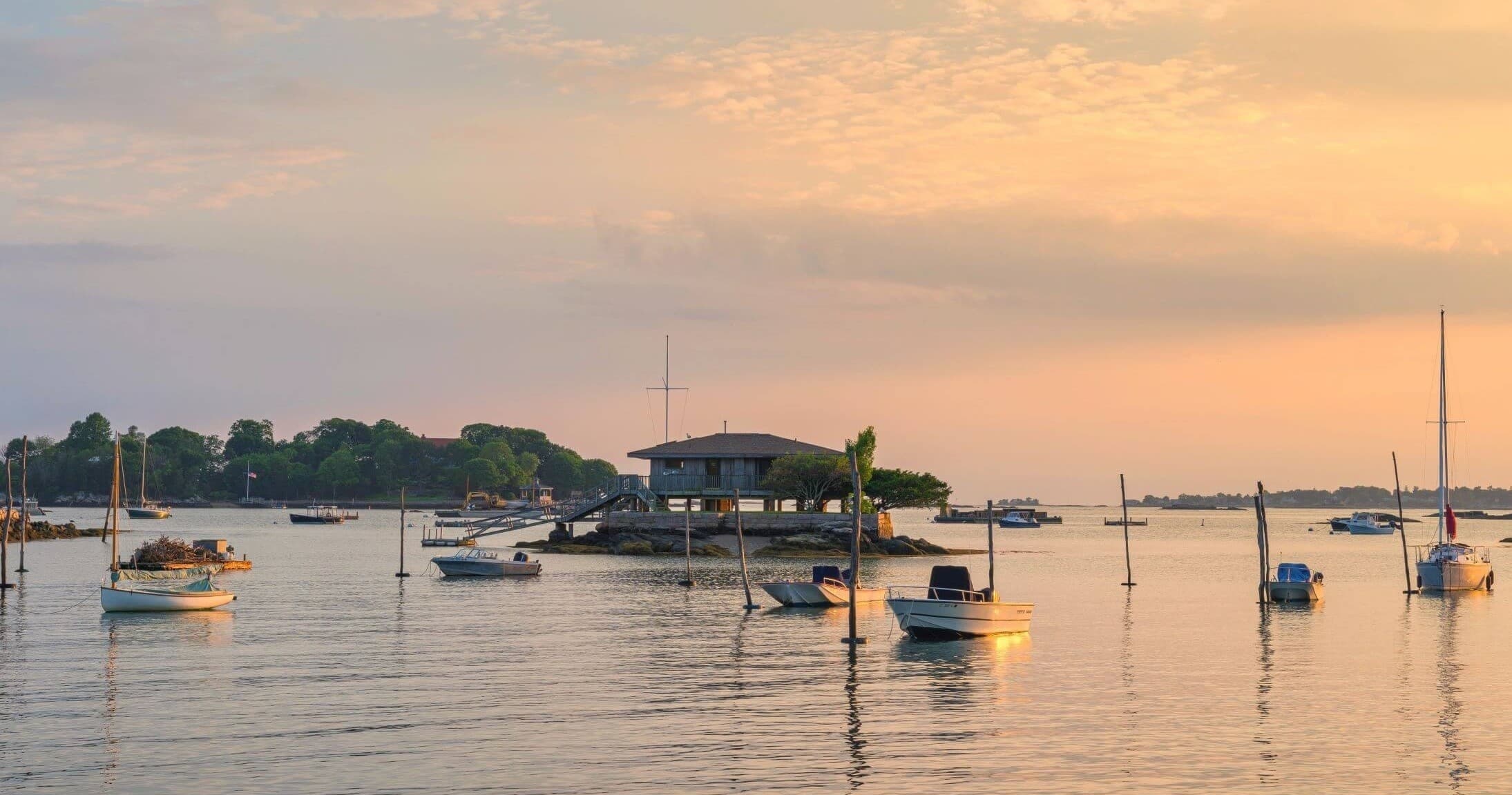Sunset harbor with moored sailboats and calm coastal waters