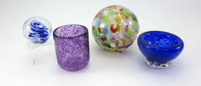 Handblown glass bowls and marble paperweights on white backdrop