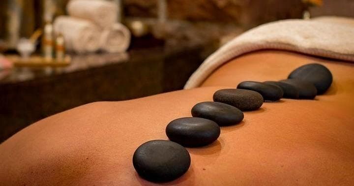 Hot basalt stones arranged on back during therapeutic massage session