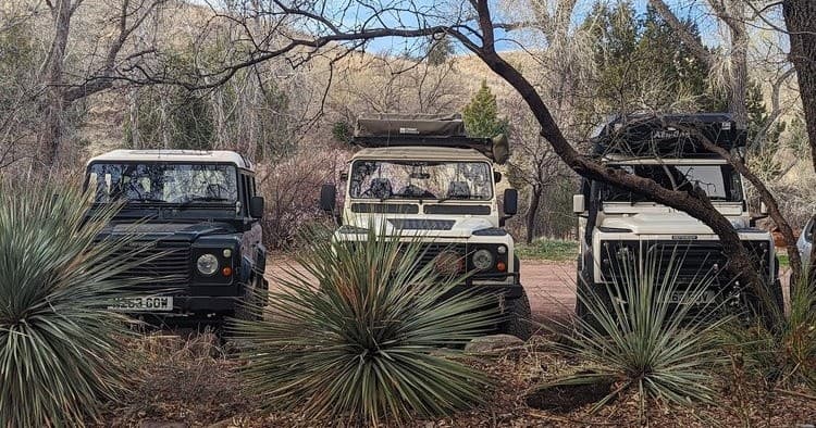 Convoy of Land Rover 4x4s parked in Sonoran Desert landscape