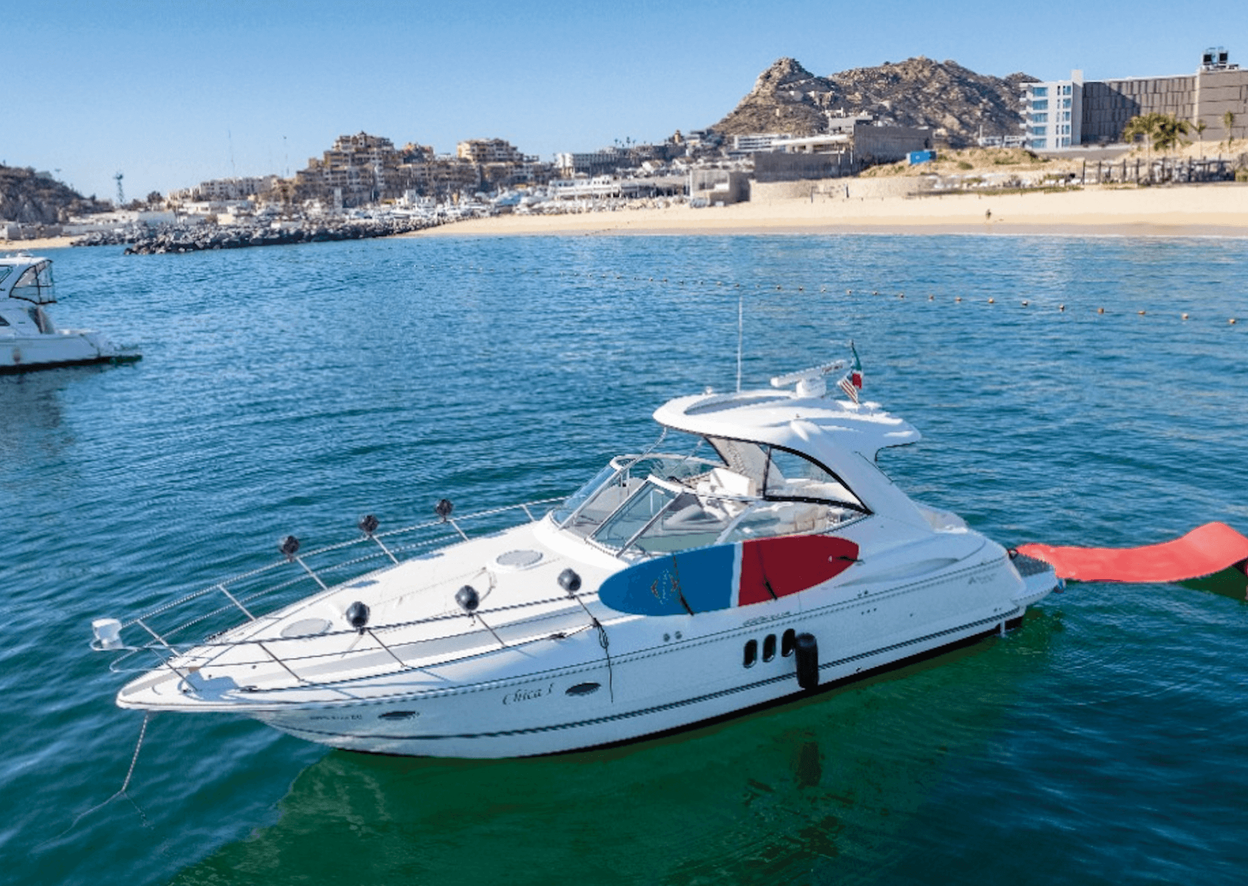 Sport yacht gliding by rocky cape with calm turquoise waters