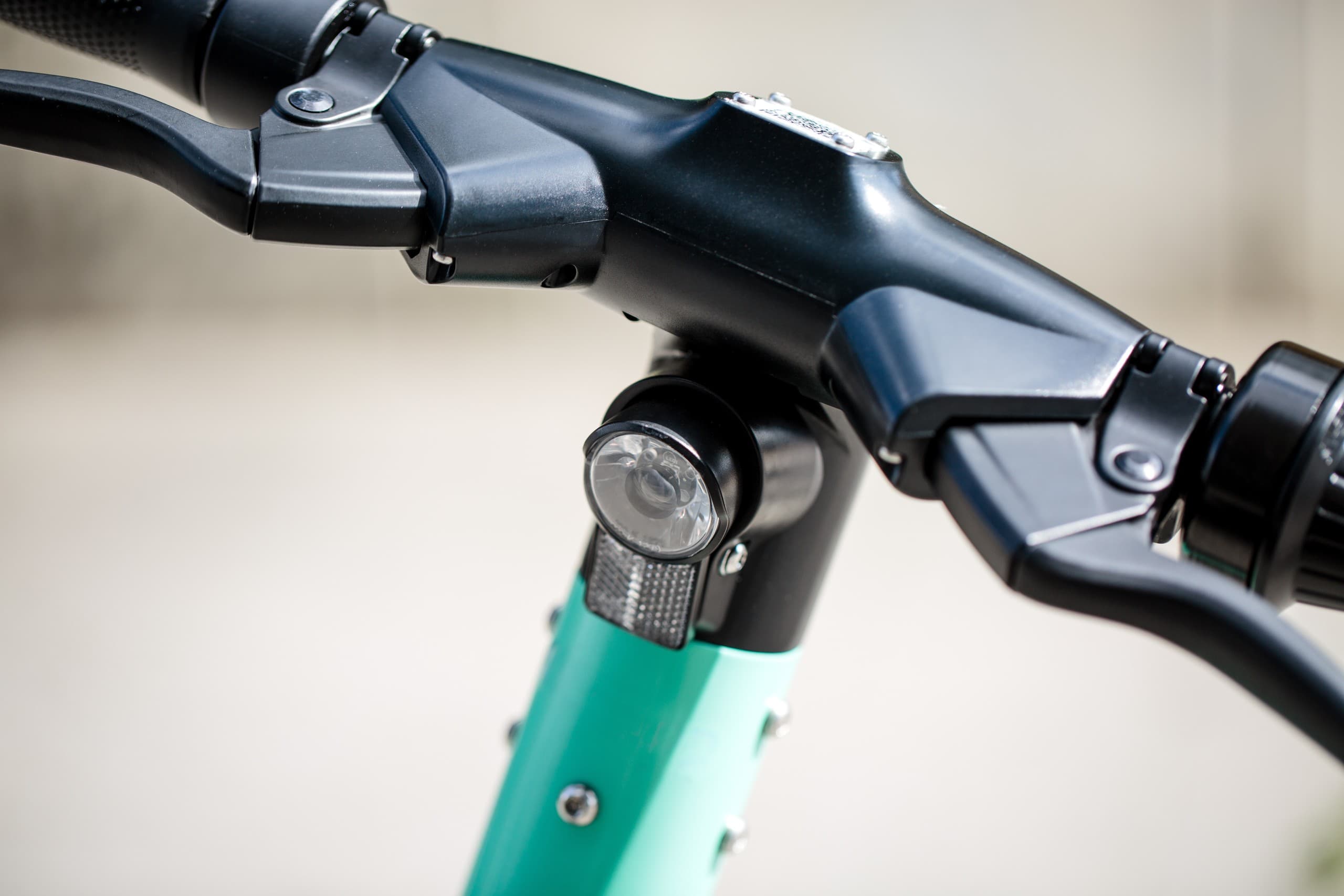 Electric scooter handlebar close-up on urban sidewalk ride