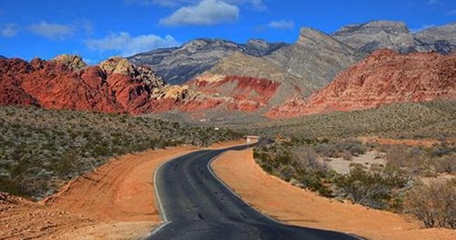 Scenic desert road winding through red rock canyons in Nevada