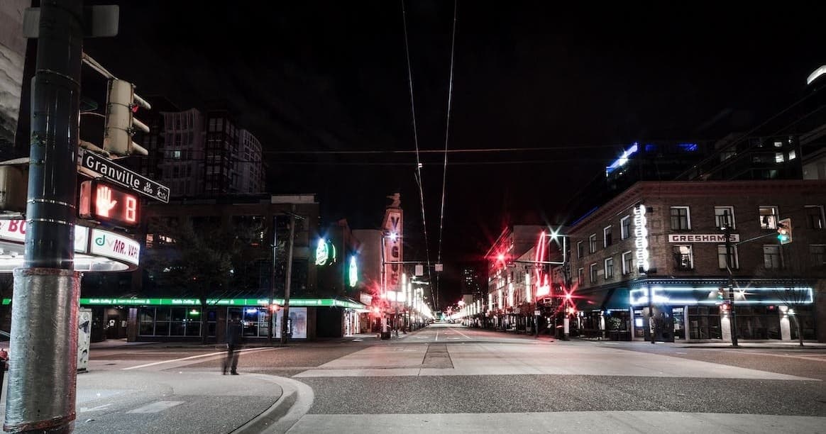 Neon-lit urban avenue at night, empty city street nightscape