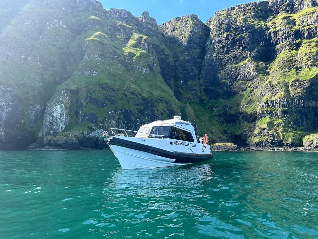Motorboat anchored in turquoise cove amid sea cliffs