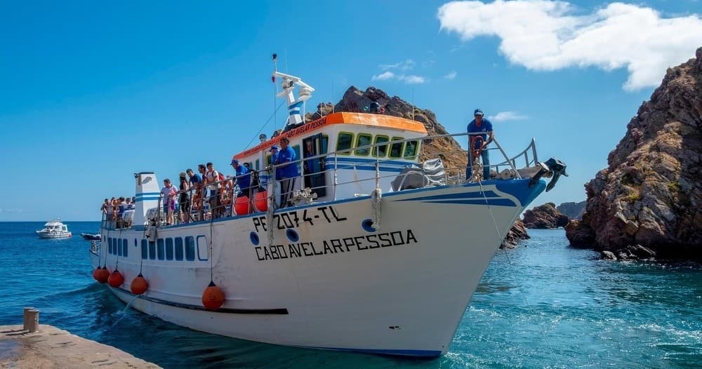 Tour boat docked at Berlenga harbor with passengers boarding