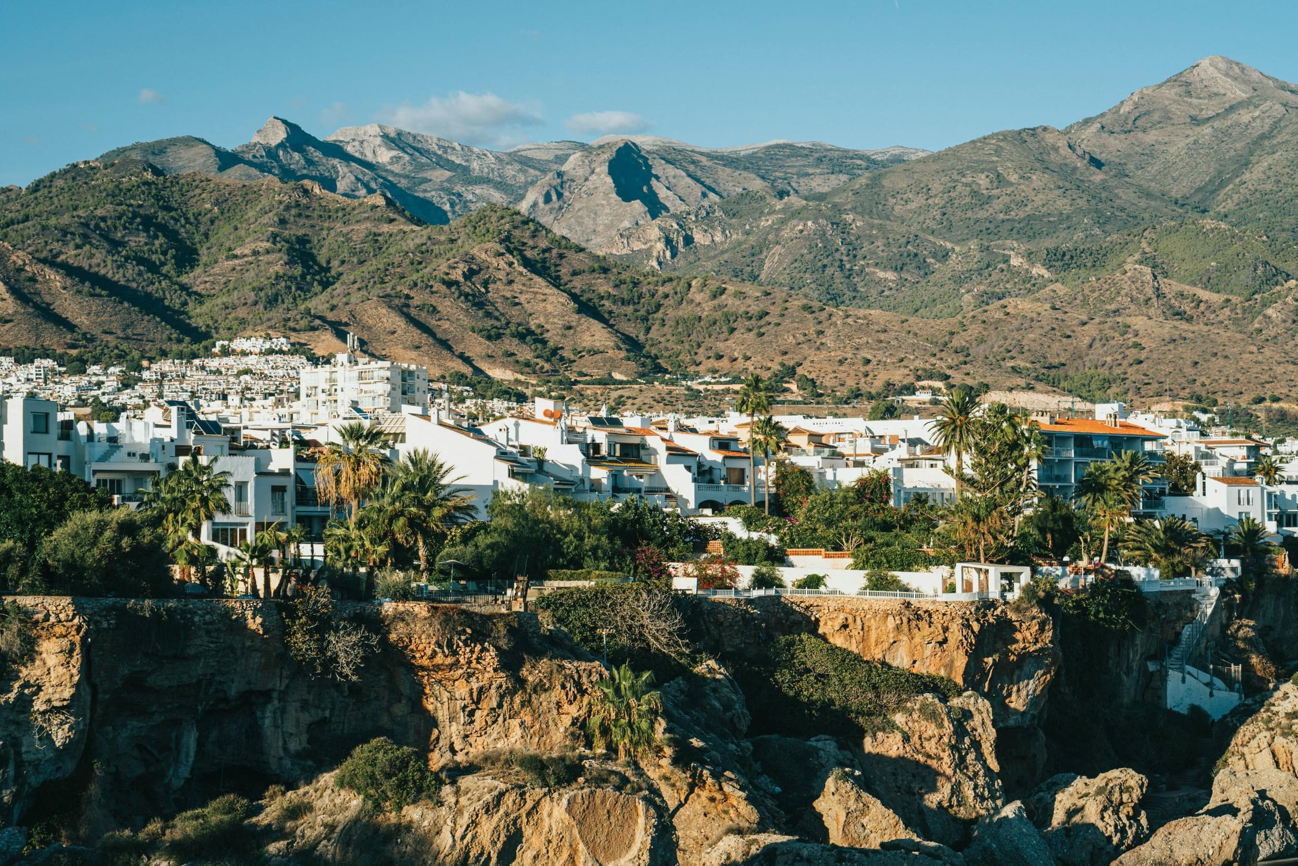 Panoramic coastal village and cliffs, cyclists exploring Andalusia
