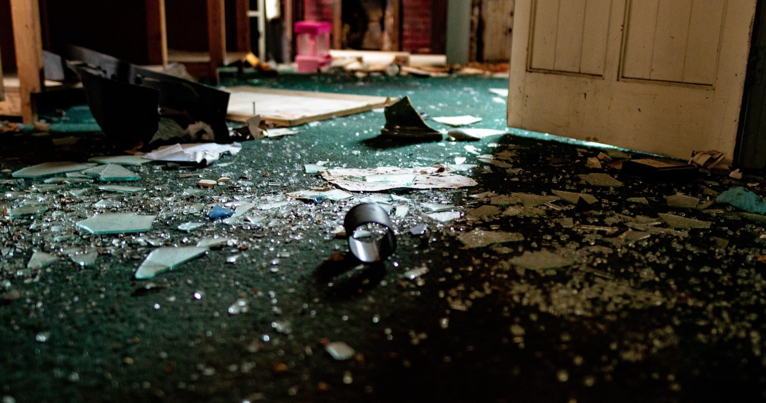 Shattered glass strewn on indoor floor during smash room session