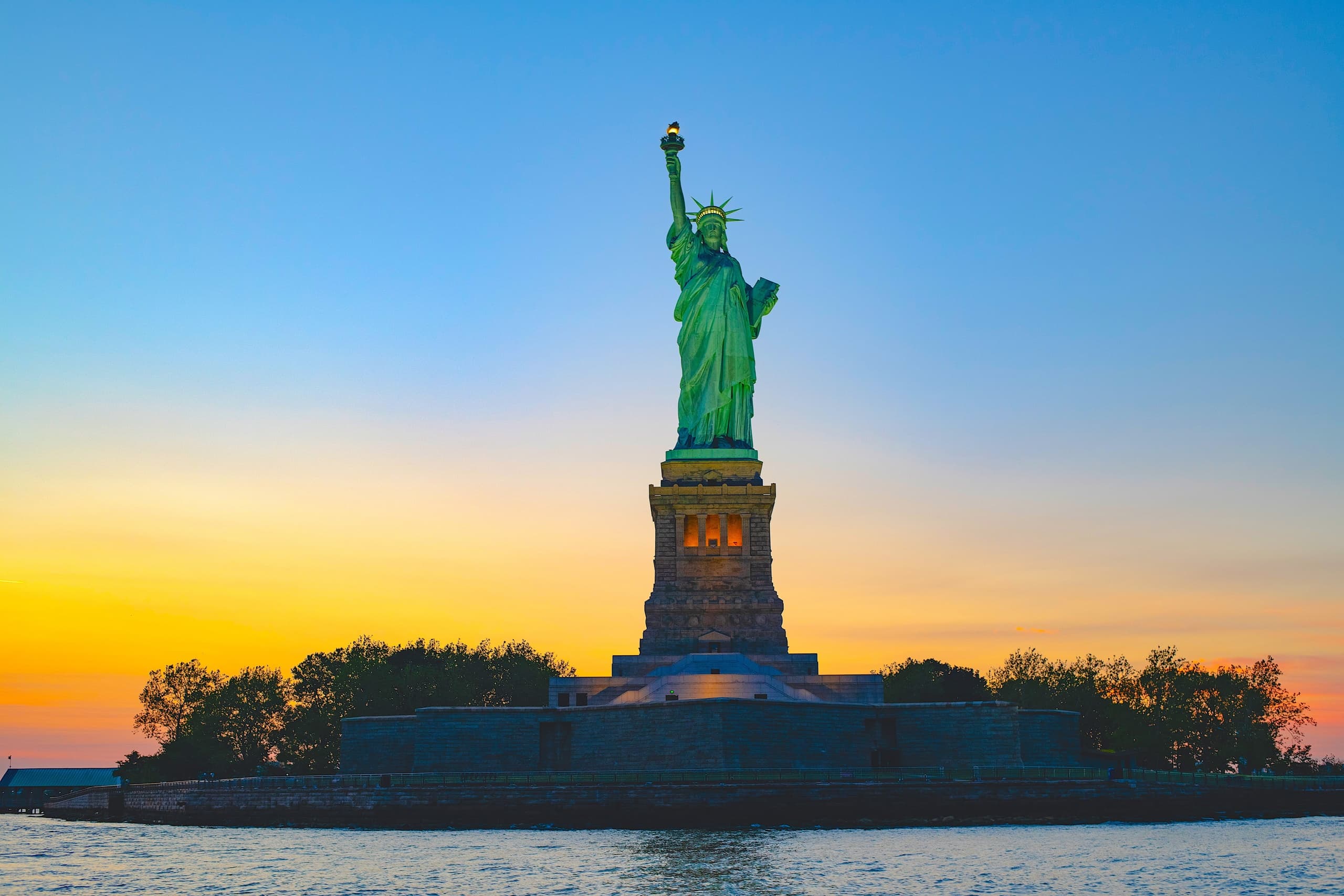Statue of Liberty at sunset seen from a NYC harbor sailing trip