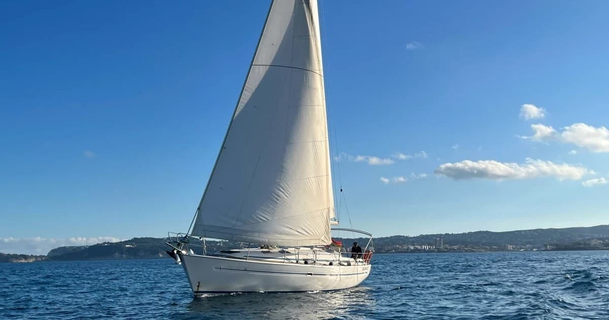 Sailboat cruising Mediterranean Sea with full mainsail