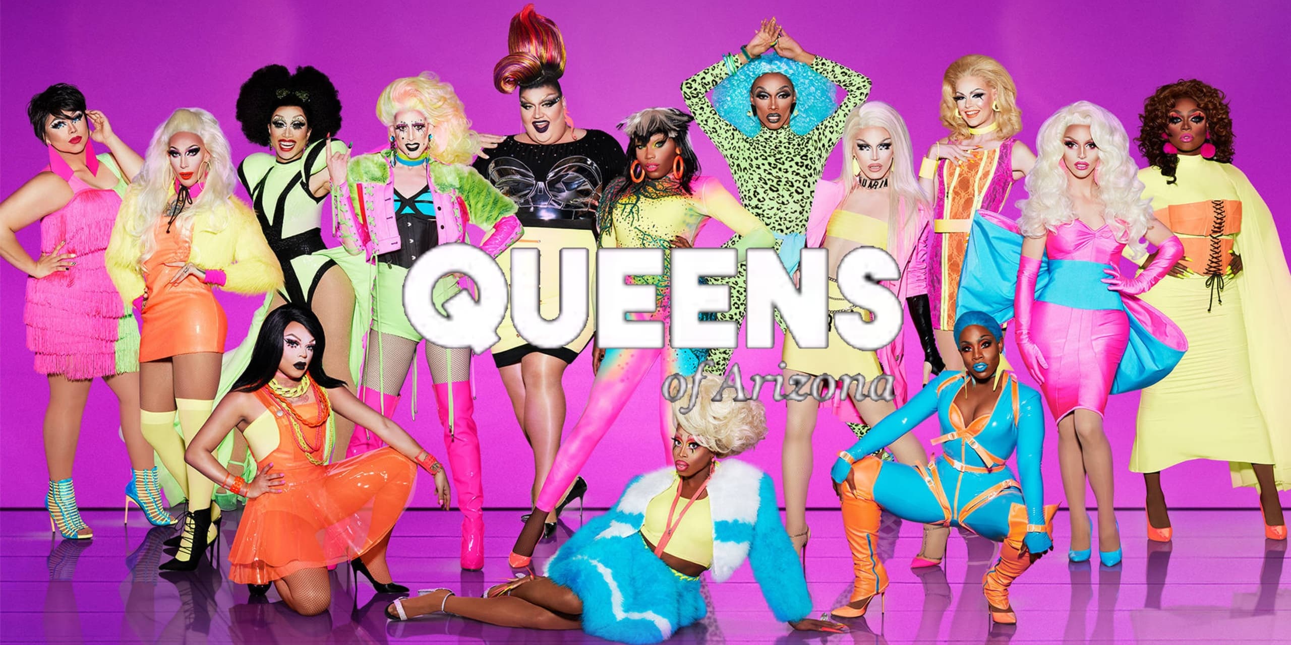 Drag performers posing in vibrant studio group portrait