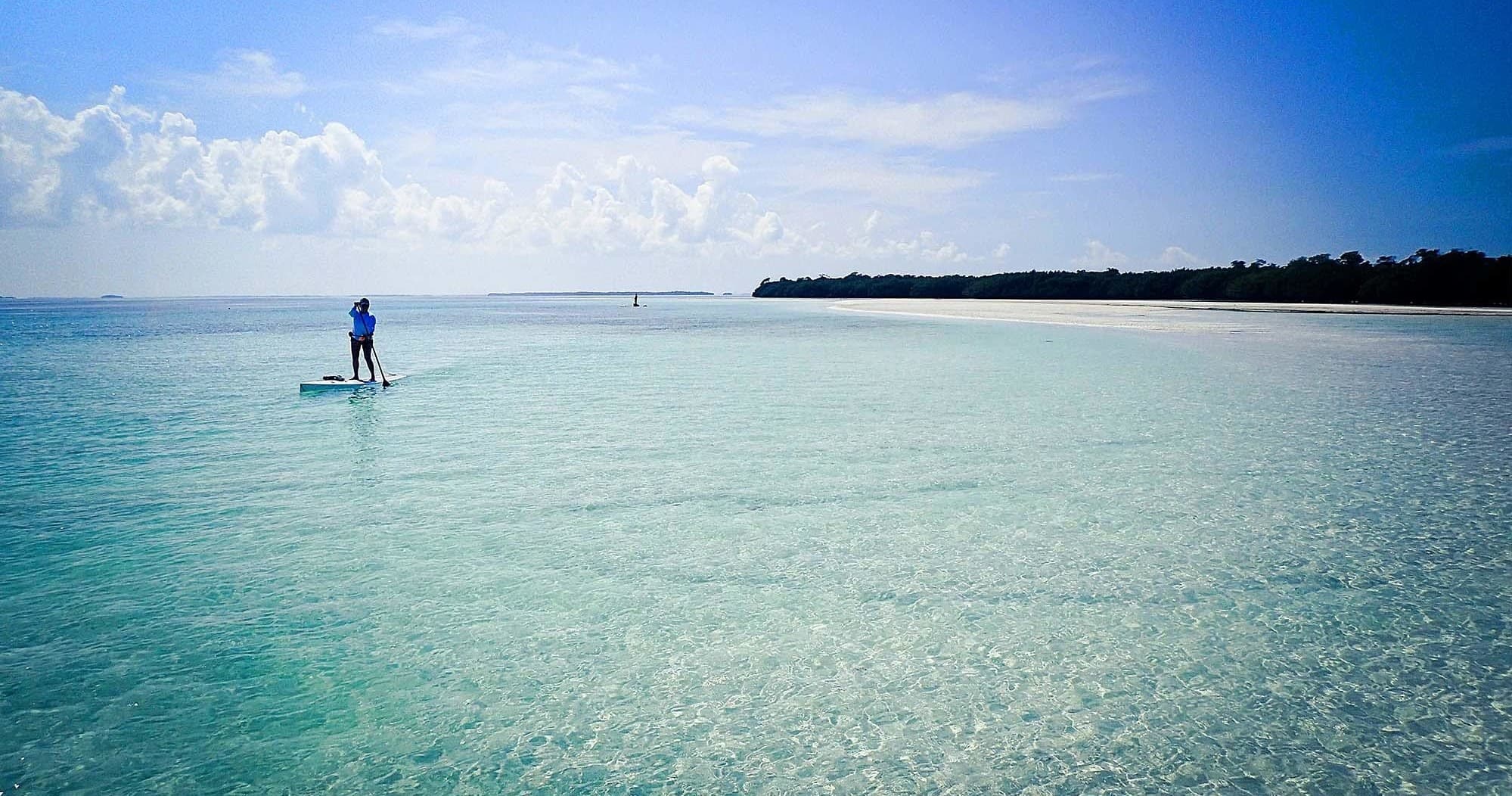 Stand-up paddleboarding across clear turquoise flats in the Florida Keys