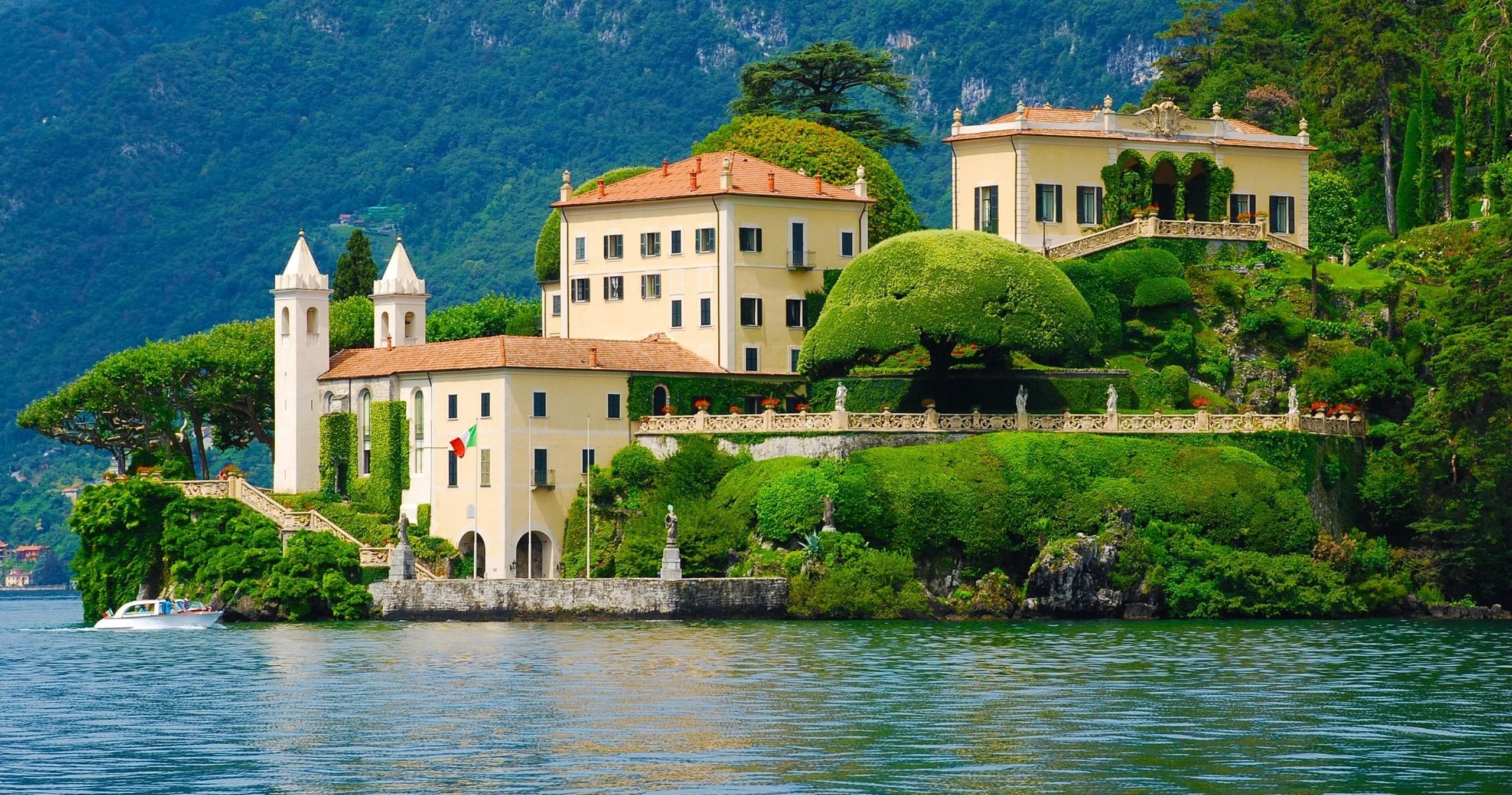 Couple enjoying scenic boat ride past villas on Lake Como