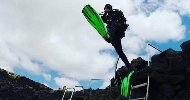 Two scuba divers silhouetted ascending in blue Lanzarote sea
