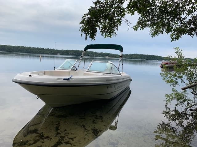 Bowrider boat grounded in quiet lake cove for peaceful cruising