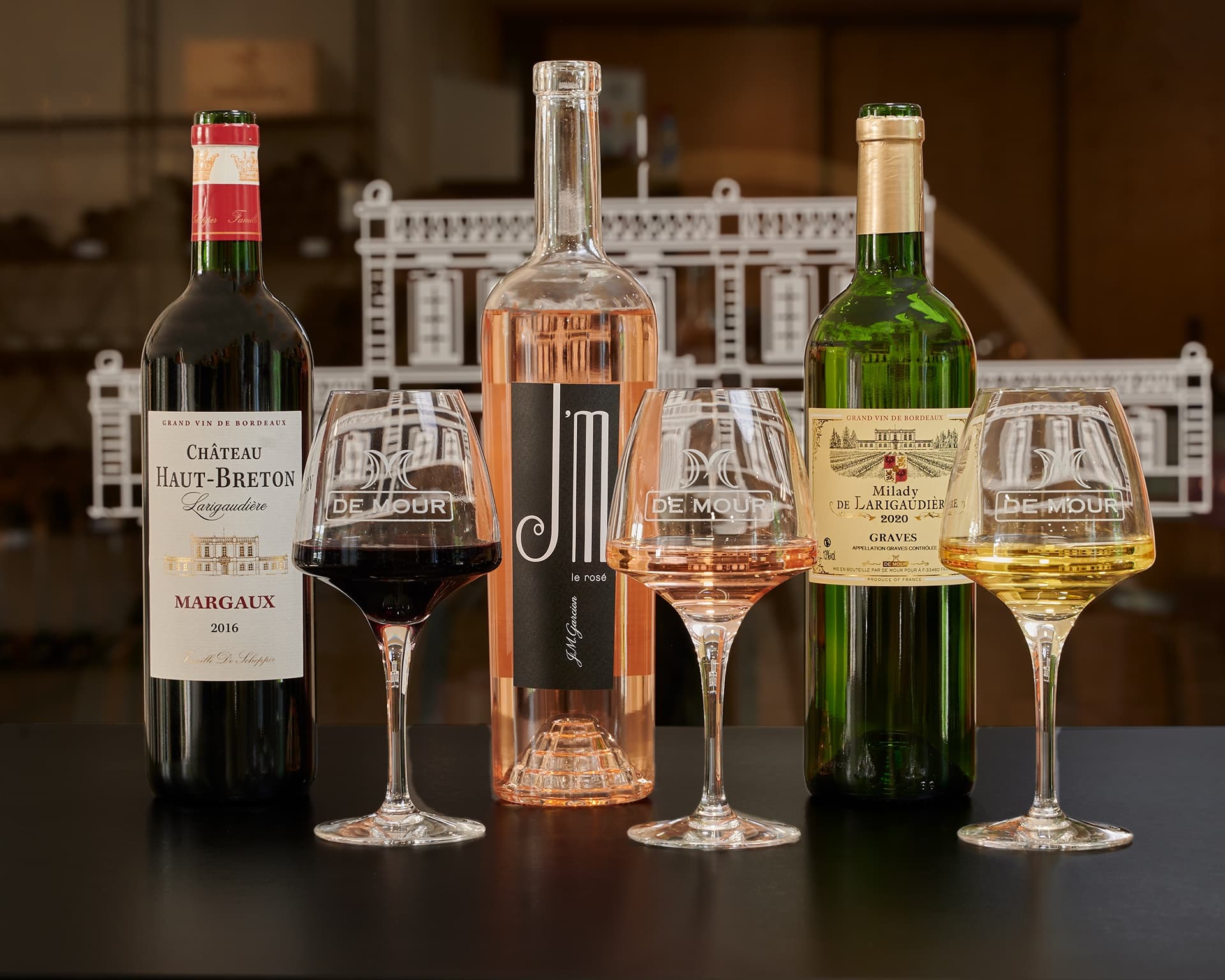 Assorted red, rosé and white wines with glasses on tasting counter