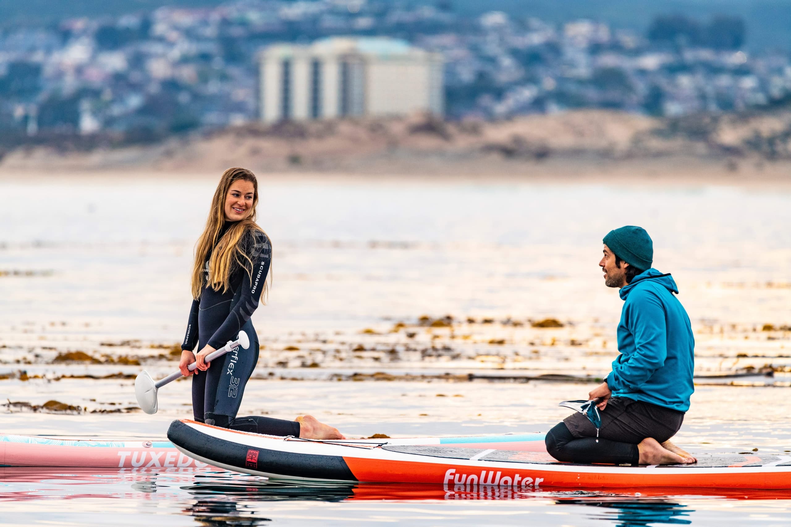 Couple on paddleboards enjoying calm bay near Monterey