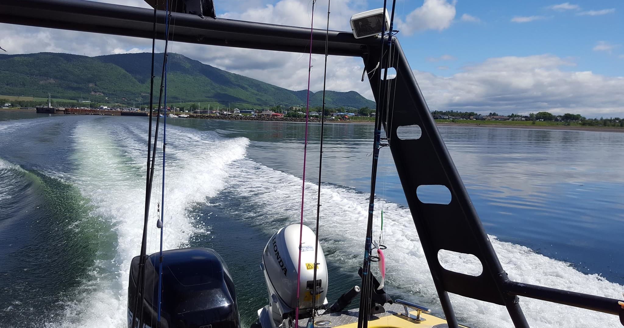 Motorboat cutting wake on calm coastal bay, offshore fishing trip
