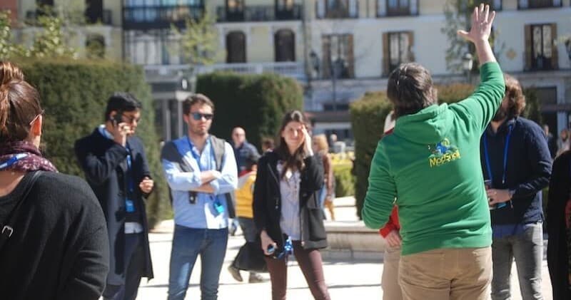 Guided walking tour group in sunny plaza, local sightseeing
