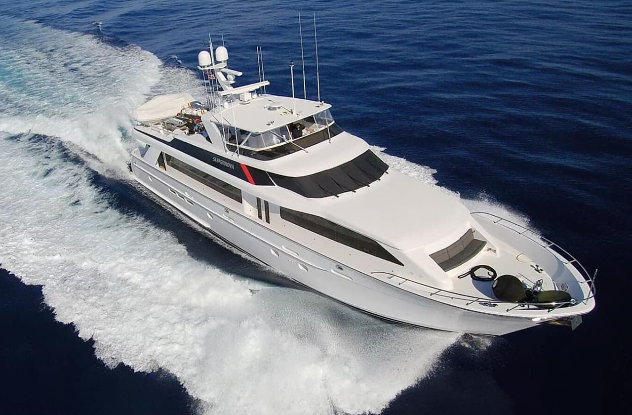 White sport yacht powering through sea spray on sunny day cruise