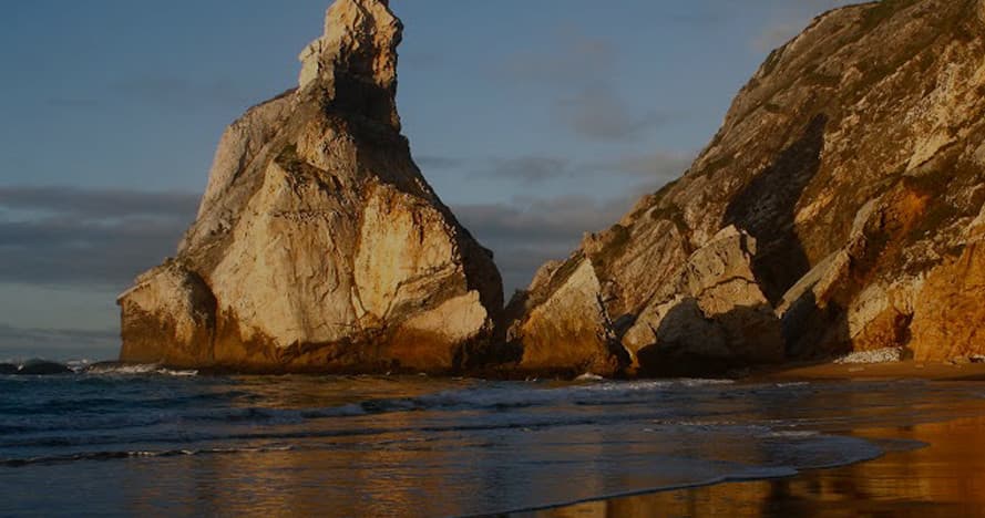 Coastal sea arch rock formation at sunset on rugged shoreline