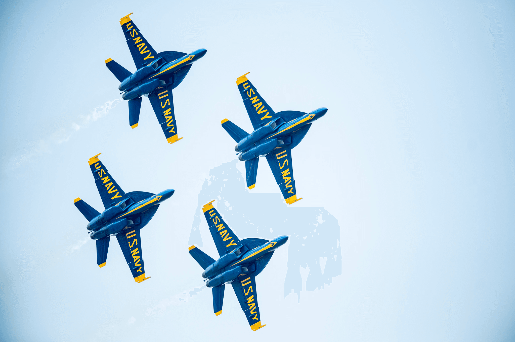 Blue Angels jets flying tight formation over clear sky