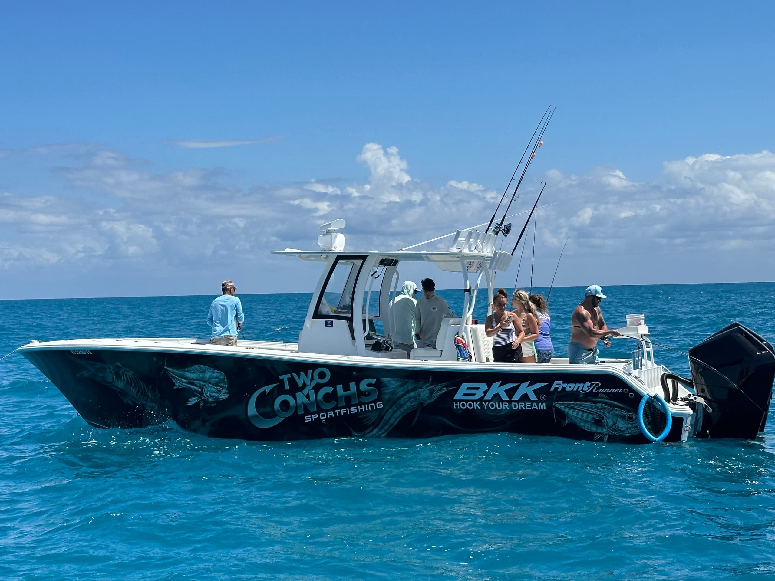 Charter sportfishing boat with crew cruising offshore in blue sea