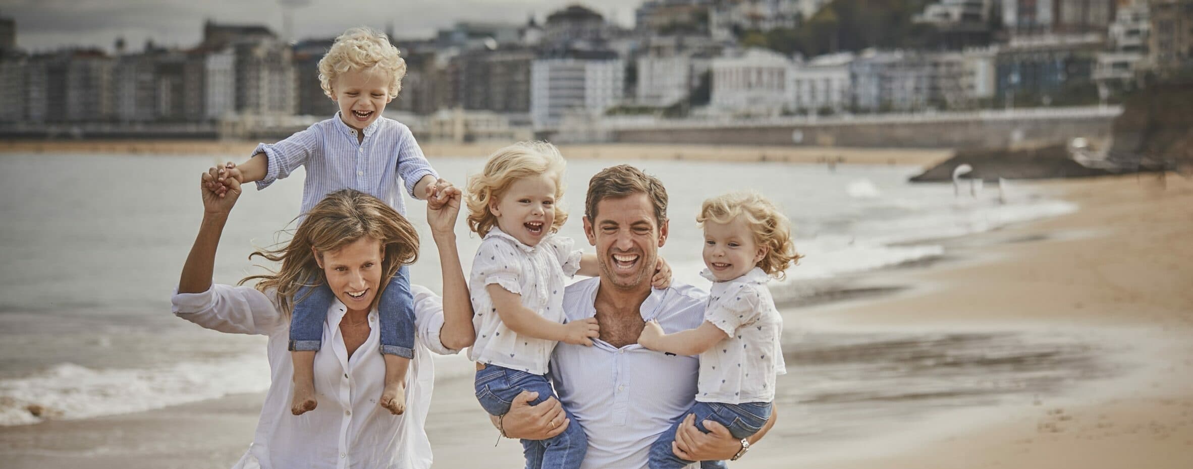 Family enjoying playful beach outing with kids on shoreline