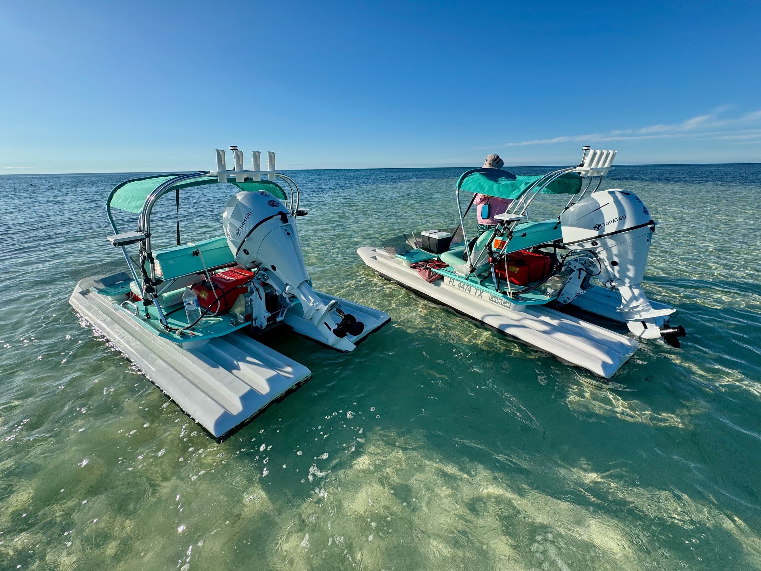 Aerial view of two pontoon boats anchored on clear flats