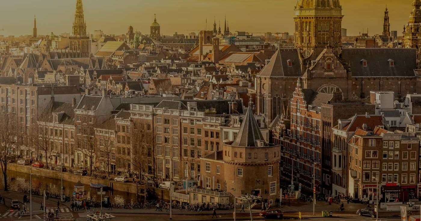 Panoramic Amsterdam canal houses skyline during urban walking tour