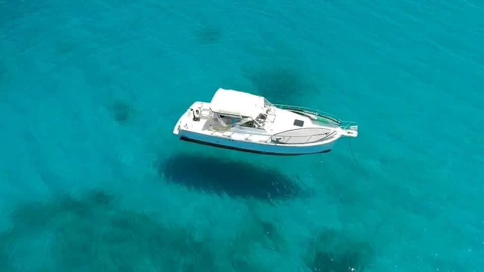 White yacht anchored in vivid turquoise Caribbean waters