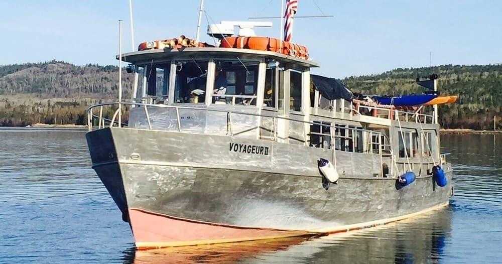Small passenger boat tied to dock at Isle Royale harbor, boarding
