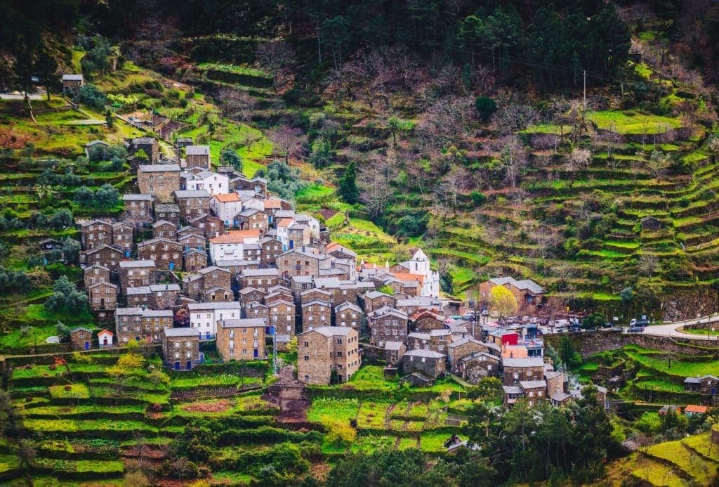 Stone terraced mountain village in lush green hills, scenic view