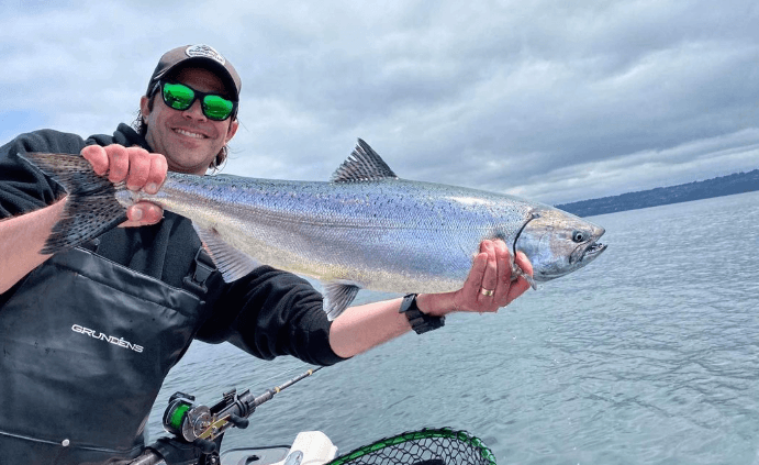 Angler holding large salmon on Puget Sound fishing charter