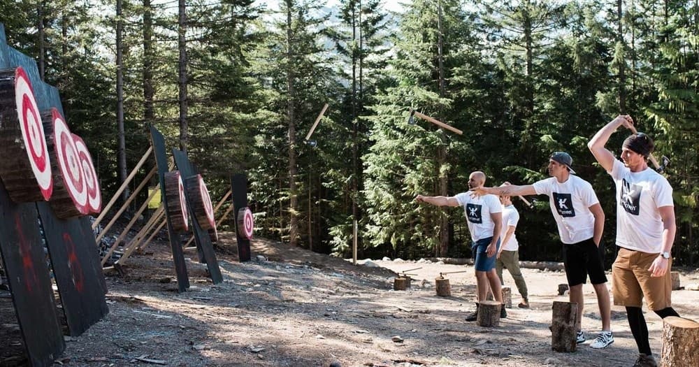 Group axe throwing at forest targets outdoors in summer