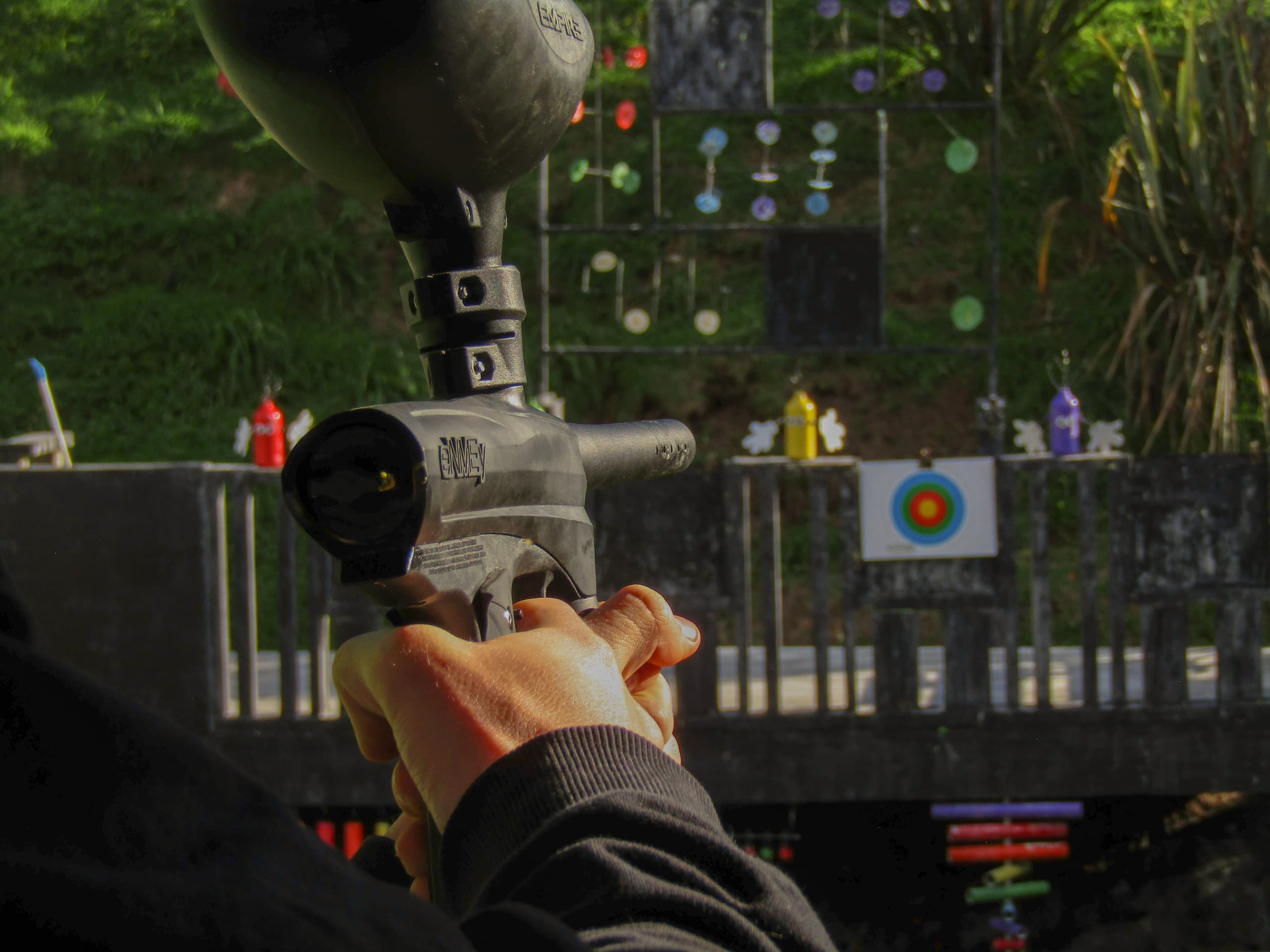 Player aiming a paintball marker at outdoor target range