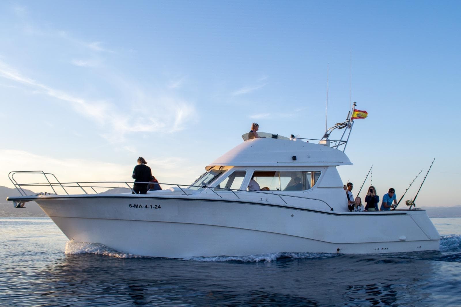 Sportfishing boat cruising coastal waters at sunrise, offshore fishing trip