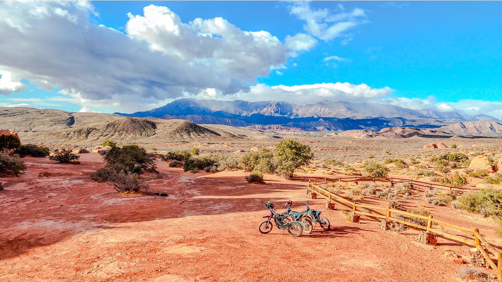E-dirt bikes parked on red desert plateau with mountain views