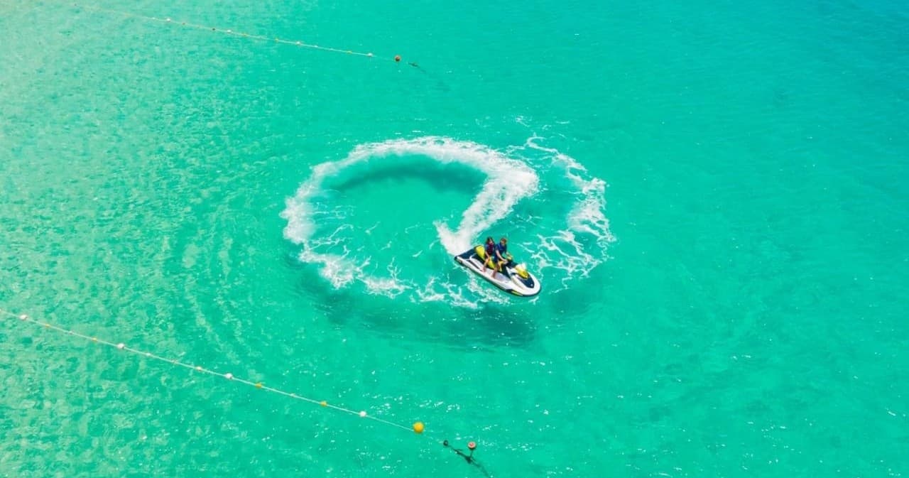 Aerial shot of boat circling in vivid turquoise lagoon